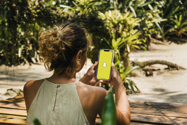 Chica sujetando un smartphone con Snapchat